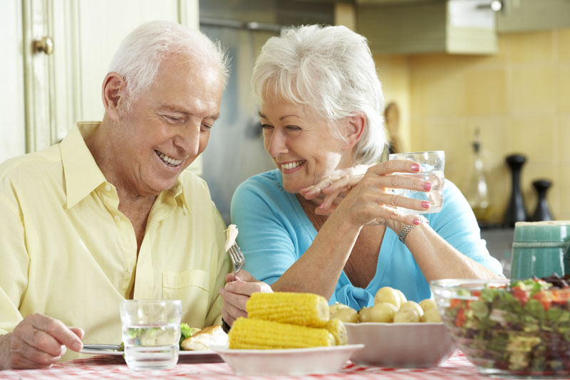 Dental Implant Patients Smiling Together While Eating