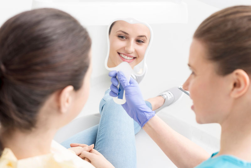 a dental patient smiling after recieving new permanent dental implants