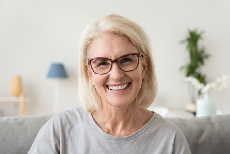 An image of a woman smiling with dental implants.