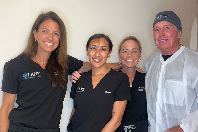 Dental team and doctor smiling brightly within the dental center