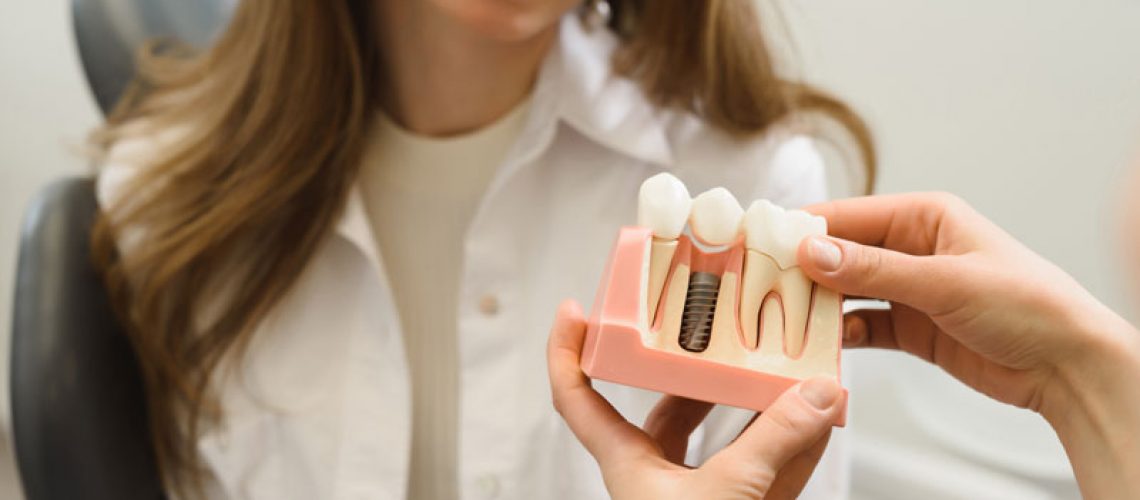 Dental Patient Getting Shown A Dental Implant Model During Her Consultation in Plymouth, MA