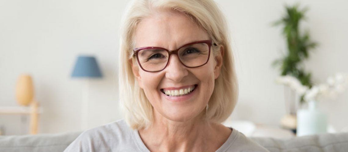 An image of a woman smiling with dental implants.
